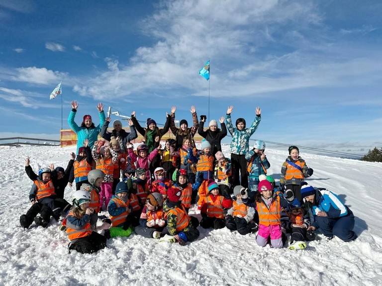 Kindergartengruppe sitzt im Schnee