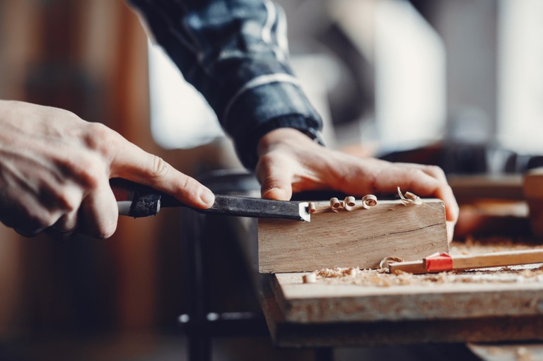 Schreiner bei der Hobelarbeit an einem Holzblock © freepik