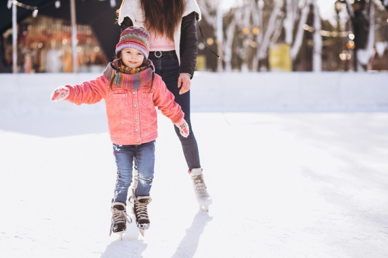 Mutter und Tochter beim Eislaufen am Eislaufplatz © freepik