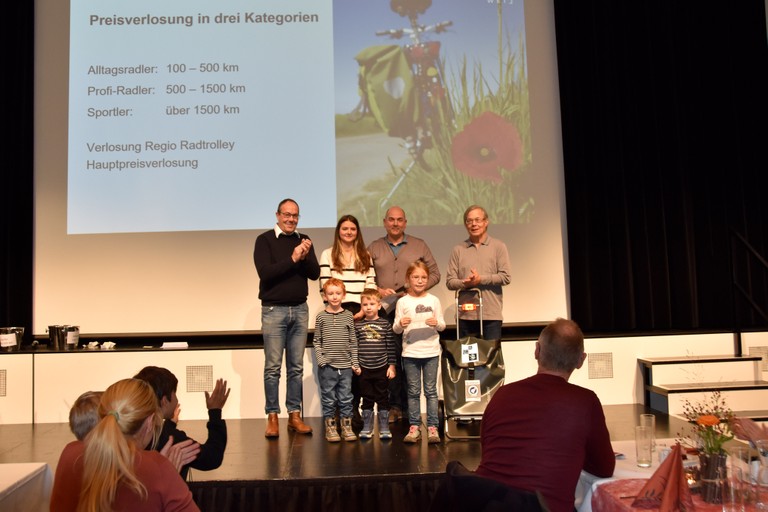 Vize-Bgm. Andreas Prenn, Katrin Ehrenbrandtner (Umweltbeauftragte der MG Rankweil) und Gemeinderat Alejandro Schwaszta mit den Gewinner*innen des Hauptpreises: Walter Silber (rechts außen) und Nora Vogl (zweite von rechts). Ebenso im Bild: die beiden „Glücksfeen“, die die Preise gezogen haben. © Marktgemeinde Rankweil