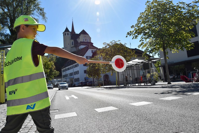 Polizist*innen zeigen den Kindern, wie ein Schutzweg zu sichern ist.© MG Rankweil
