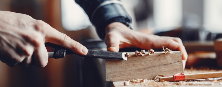 Schreiner bei der Hobelarbeit an einem Holzblock © freepik