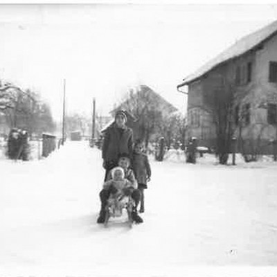 Die Kreuzung Hasengasse-Schöffenstraße-Südtiroler straße im Jahr 1961, im Hintergrund ist „s`Alge Hus“ zu sehen. Die Straße eignete sich ideal zum Rodeln: Es gab keine Asphaltierung, keine Kanaldeckel und kaum Verkehr.