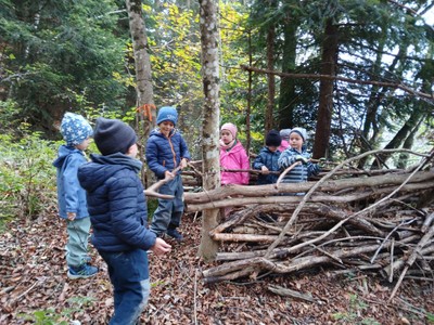 Hier reparieren die Kinder gemeinsam ein verfallenes Bauwerk im Wald.jpg