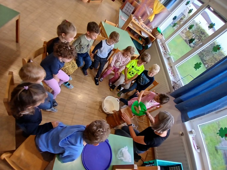 Ingrid zeigt den Kindern wie aus Körnern Mehl und aus Mehl Brot wird.