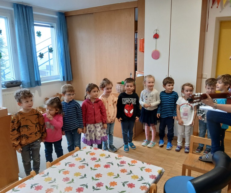 Die Kinder singen den Eltern ein Lied vor.